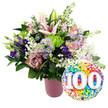 A radiant 100th celebration bouquet is displayed against a bright white background, its colours and shapes arranged with the care of an experienced Grove Park florist. The flowers are gathered in a modern, matte pink vase with a ribbed texture that catches the light in fine vertical lines, adding quiet elegance. Rising from the centre of the bouquet, pale pink lilies command attention; some are fully open, star-shaped and expansive, their petals soft and smooth, while others remain in tapered buds, tinged with blush at the tips. Around them, roses in tender blush pink and deeper dusty rose shades open in concentric circles of velvety petals, evoking warmth and affection built over many decades. Rich purple lisianthus thread their way through the arrangement, their ruffled petals and cup-like blooms bringing depth and sophistication. Interspersed among the larger flowers are petite lavender asters, each tiny daisy-like bloom with a bright yellow centre adding a cheerful, garden-inspired touch, like a glimpse of a summer border near Grove Park's leafy streets. Small lime green button chrysanthemums appear here and there as vivid, rounded bursts of colour, their many fine petals creating a pleasing contrast to the more open, showy blossoms. Delicate stems of white baby's breath weave throughout, forming airy clouds that lighten the look and tie the various elements together. A mix of deep green foliage-some shining and broad, others slender and softly arching-frames the display and emphasizes its generous fullness. To the lower right of the bouquet, slightly overlapping the flowers, a shiny round foil balloon introduces an unmistakably festive note. Its surface is scattered with bright confetti dots in red, orange, yellow, green, blue, and purple, while in the centre, the bold white number 100 stands out with a gentle 3D effect, clearly marking the centenary occasion. Together, the bouquet and balloon create a vivid, heartwarming tribute to a century of life, perfect for delivery to families across Grove Park.
