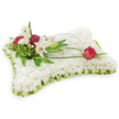 A gently rectangular pillow of flowers, the surface a plush sea of tiny white chrysanthemum blooms that read like soft, clouded fabric beneath the eye. The chrysanthemums are packed so closely their petals form a uniform, tactile sweep; you can almost feel the cool, velvety texture under a fingertip. Around the edge a pleated pale lime-green satin ribbon has been hand-folded into a delicate frill that catches a soft sheen from the studio light, giving the cushion a subtle, refined frame. The overall palette is spare and peaceful - white and soft green - and the arrangement rests against a clean white background that emphasises its serenity and quiet presence.

On the upper left a naturalistic vignette draws the gaze: two open white Oriental lilies, their broad petals unfurling to reveal warm yellow stamens, stand beside a neatly closed lily bud. Interspersed are clusters of deep burgundy spray carnations, their ruffled heads offering warm contrast and textural depth. Lush, varied green foliage - feathery fern fronds and broader glossy leaves - forms a verdant backdrop, while a slender arch of salal leaf or decorative wire curves from that cluster across the cushion like a gentle hand. The arch terminates on the right with a single deep red rosebud, just beginning to open, its velvety petals suggesting abiding love and respect. The lilies give a faint, sweet aroma that balances the composition's visual hush.

This traditional sympathy pillow, shaped and finished for a memorial or funeral, conveys comfort and reverence, the kind of understated, compassionate tribute you might choose for a service in Grove Park or a quiet chapel near Chinbrook Meadows.