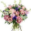 A lush, romantic bouquet is presented against a clean white background, allowing every nuance of its colour and texture to stand out clearly, as if displayed in the window of Grove Park Florist. The hand-tied arrangement is rounded and abundant, built around a palette of soft pinks, dusty mauves, deep indigos, and layered greenery. At the centre, roses in gentle shades of dusty rose and pale peach open in varying stages, from tightly held buds to fully blossomed flowers with velvety, spiralling petals that invite contemplation. Surrounding them are opulent carnations whose frilled, two-tone petals shift from creamy blush at the core to vibrant magenta along the edges, adding both volume and visual intrigue. Deep indigo and violet-blue anemones are woven through the softer tones, each featuring a distinctive, dark central eye that introduces drama and sophistication, much like the contrast between quiet residential lanes and the nearby Thames in Grove Park. Slender stalks of pale pink and lavender stock thread their way among the larger blooms, bearing numerous dainty florets that form soft, feathery spires and suggest a gentle, sweet fragrance drifting through the air. The flowers are embraced by an assortment of foliage: rounded, silvery eucalyptus leaves glimmer with a cool sheen, while darker, broader greens provide depth and structure. At the base, the natural stems are clearly visible, neatly gathered and hand-tied, giving the bouquet an honest, garden-fresh character. Bright, even lighting enhances the richness of each colour and the fine detail of every petal and leaf. The overall impression is one of calm elegance and heartfelt warmth, ideal for birthdays, anniversaries, or same-day deliveries across Grove Park when you want to send a meaningful, beautifully crafted floral gift.