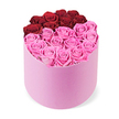 Inside a soft-pink velvet cylindrical hatbox, a luxurious floral display rests perfectly centered on a pristine white backdrop. The box's plush exterior seems almost tactile, inviting a gentle touch as the blooms spill out in a curated, couture arrangement. Dozens of fully opened roses become the heart of the design, their petals arranged in two distinct blocks of colour. At the very top, a curved crescent of about a dozen deep crimson red roses forms a dramatic edge that hints at romance and celebration. Beneath this, the larger lower half is filled with bright fuchsia pink roses, creating a vibrant, modern contrast that feels equally warm and sophisticated. Each bloom is lush and perfectly open, with layered petals that catch the light and glow with freshness, suggesting premium fresh-cut stock or long-lasting preserved varieties.

The composition reads as an elegant gift for love and special occasions, whether for Valentine's Day, an anniversary, or a sophisticated home centerpiece. The soft pink hatbox amplifies the romance, while the crisp white background keeps the focus squarely on the flowers and their texture. The result is a refined, product-shot presentation that communicates quality, luxury, and thoughtful gifting. For customers around Grove Park seeking a statement rose gift, this arrangement is available for delivery across Grove Park and nearby streets, with same-day options to homes and offices in the area. It's the kind of bouquet that invites a quiet moment of admiration, a gesture that can brighten a room and a day, opened with anticipation and a full heart.