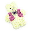A delicate teddy bear-shaped floral arrangement is captured here in clear, even light against a pristine white background, creating a simple stage for a deeply emotive tribute often chosen by families in Grove Park. The entire bear, from its round head to its compact little feet, is made from tightly placed white chrysanthemums, their creamy petals forming a dense, velvety coat of floral fur. The blossoms are arranged with meticulous care so that the curves of the cheeks, the gentle slope of the forehead, and the soft roundness of the belly all feel natural and harmonious, much like a cherished teddy left on a windowsill overlooking the trees near Grove Park Terrace. At the centre of the face, two tiny, dark flower centres or decorative elements create the eyes, and a small black nose sits just beneath, giving the bear a mild, reassuring gaze and a barely-there smile. Across the chest, the florist has shaped a waistcoat using deeper pink and mauve blooms, which stand out warmly against the pale foundation of chrysanthemums. These vest flowers have a slightly different texture-richer, fuller, and more ruffled-adding visual interest and a sense of the bear being dressed smartly for an important occasion. Completing the design is a dainty bow of translucent purple netting positioned at the neckline, its delicate mesh softening the transition between head and body. There are no other props or distractions, allowing the viewer's attention to rest wholly on the bear's form and expression. Created as a funeral or memorial tribute for a child, baby, or beloved soul, this floral teddy radiates gentleness and care, a quiet symbol of love that would feel at home in services across Grove Park, Chiswick, and the nearby riverfront communities.